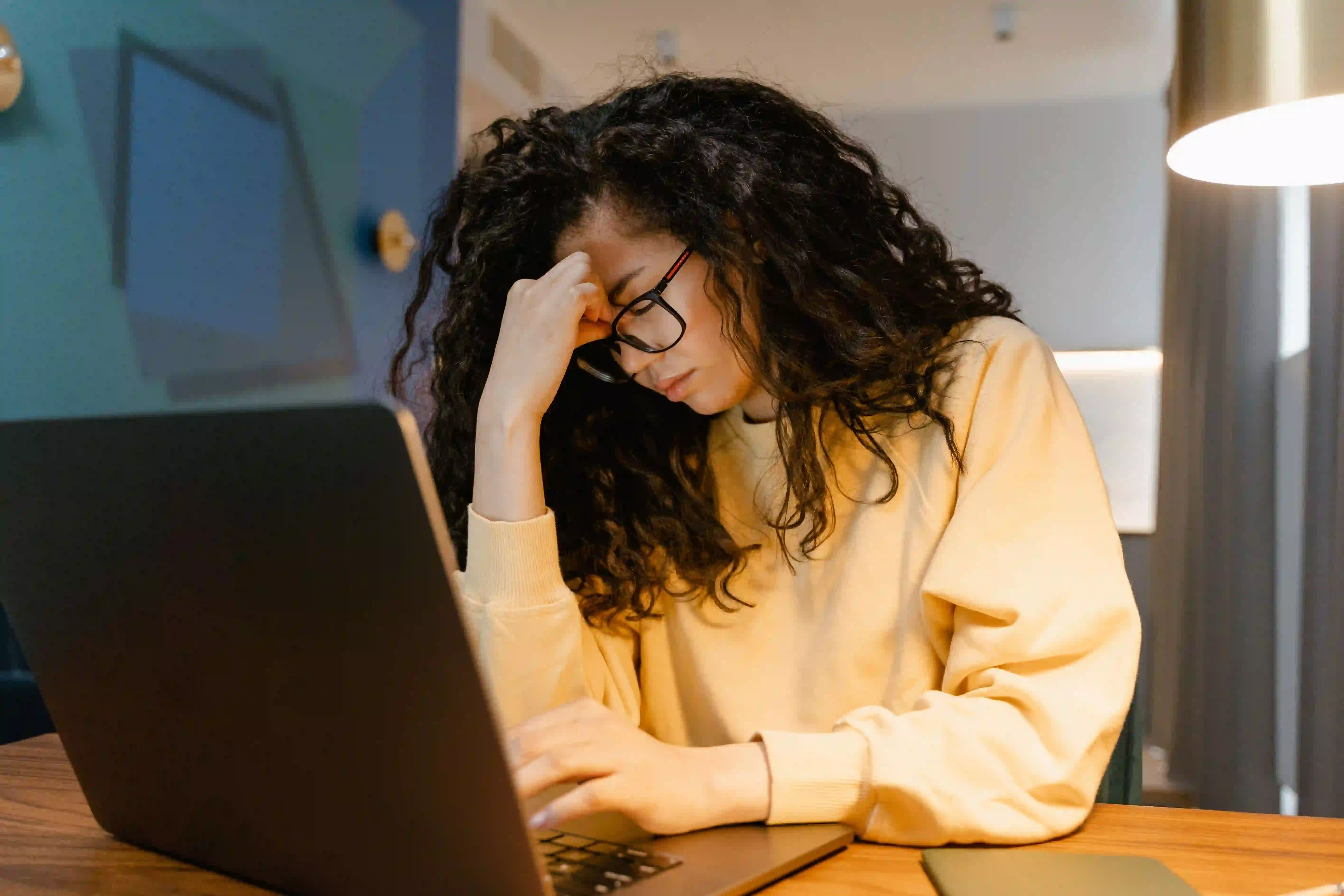 Erschöpfte Frau am Laptop — Cortisol oder Wechseljahre als mögliche Ursache