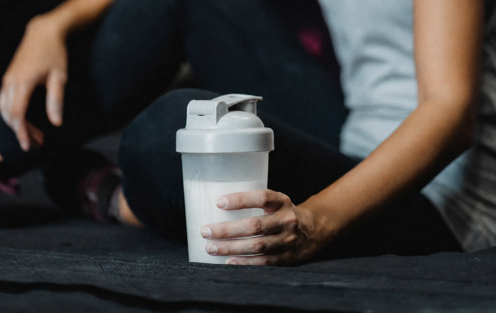 Frau mit Protein-Shaker nach dem Training