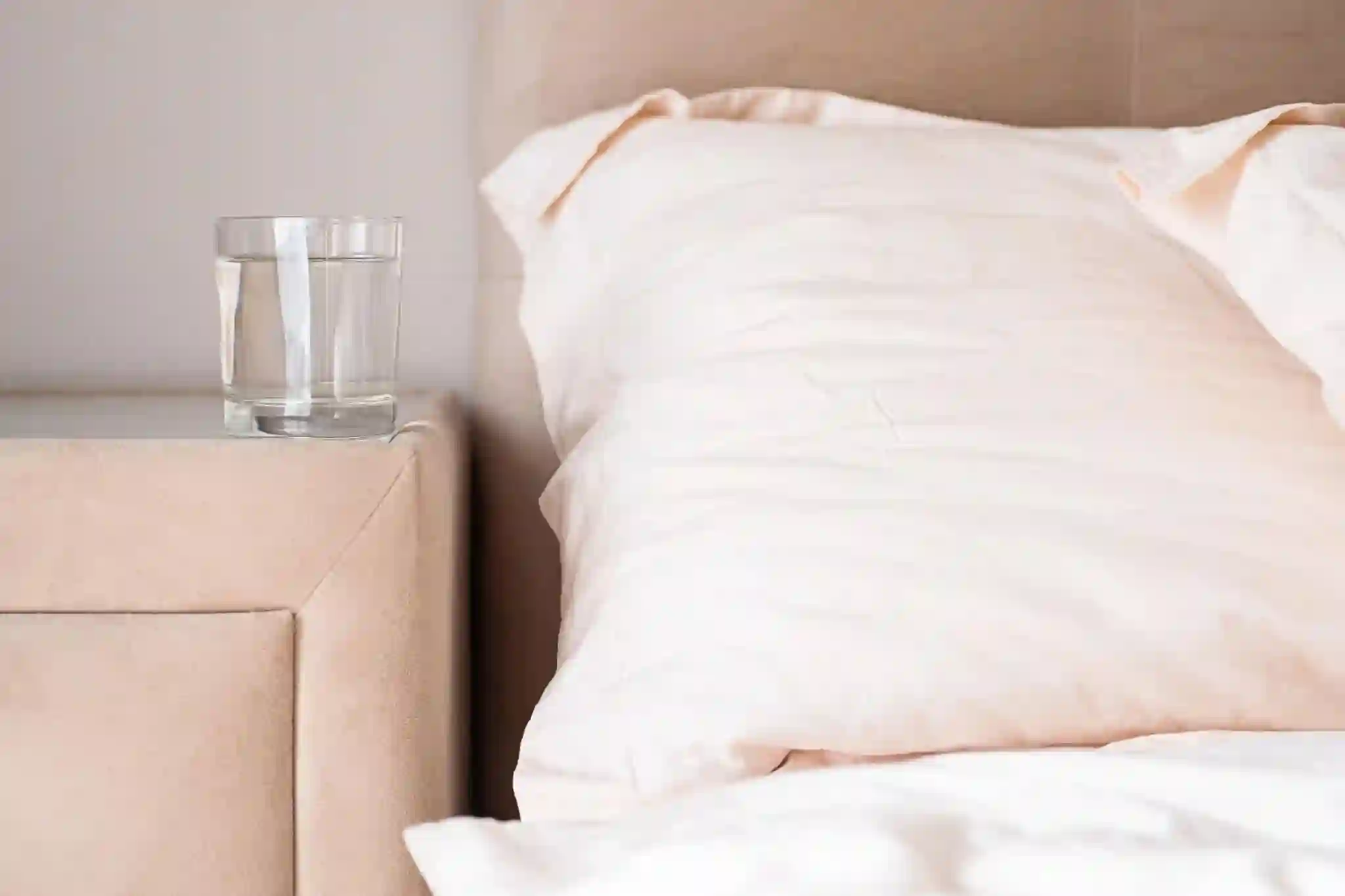 Bett mit Wasserglas — Schlaf als hormoneller Regenerator
